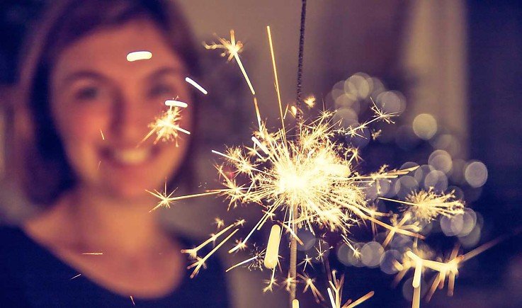 L�chelnde Frau mit Wunderkerze